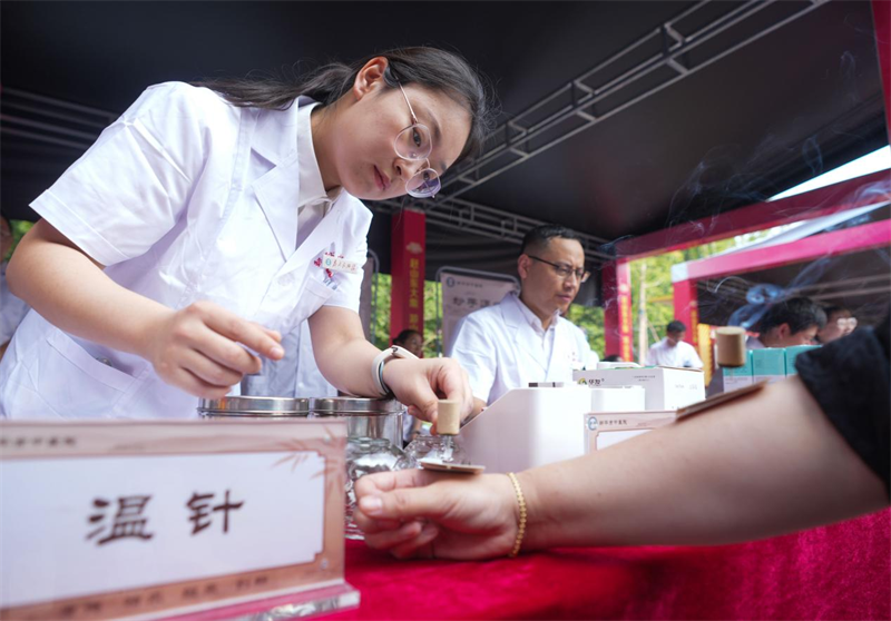 6月28日，在山東省鄒平市的夏季“黃河大集”中醫(yī)養(yǎng)生市集，醫(yī)生為顧客艾灸。